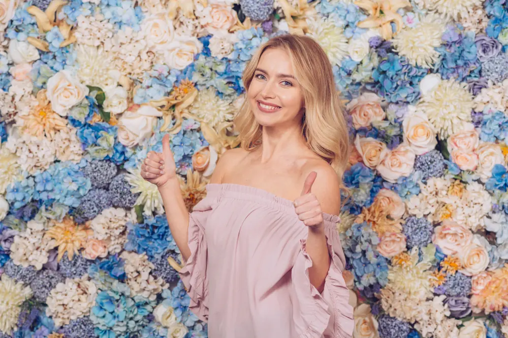 A woman in a pink dress standing in front of flowers
