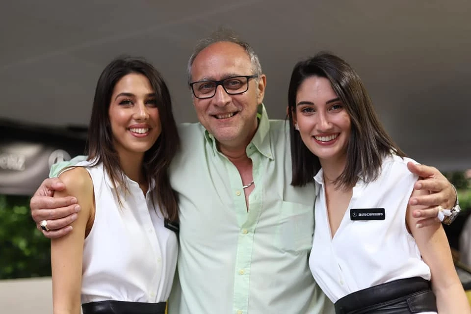 A smiling gentleman standing with two women at an outdoor venue